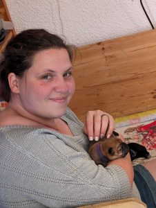 Claudia mit einem Welpen auf dem Arm in der Wurfkiste.